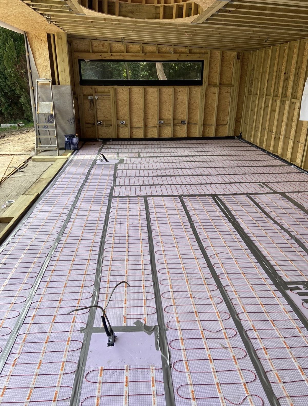 Underfloor heating pipework being laid during first fix on a new extension